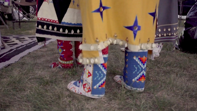 Women wearing Plains Tribes Traditional Native American Clothing with colorful beadwork and decorated leggings